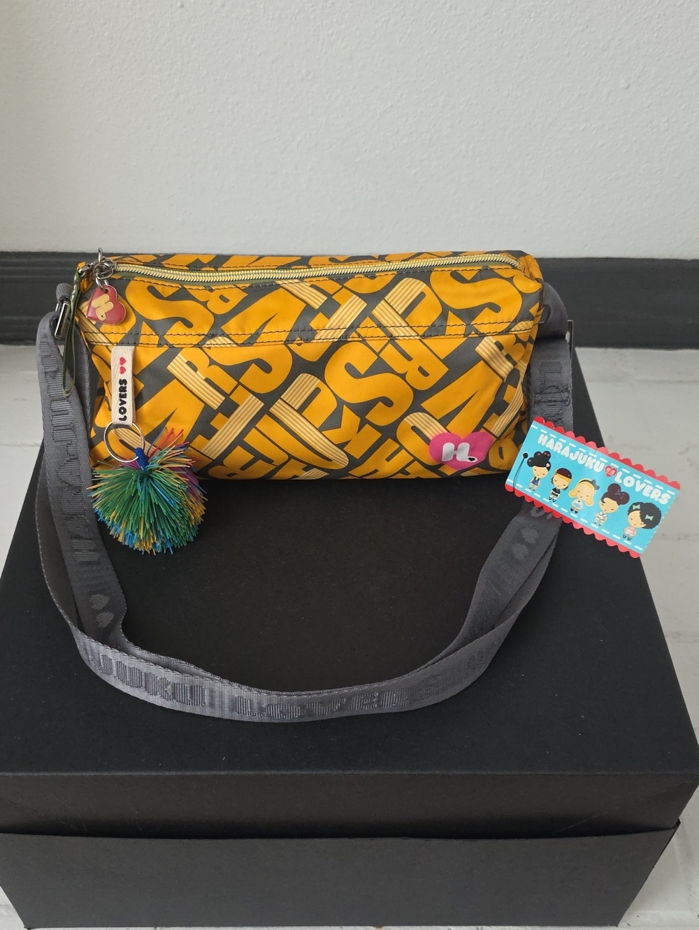Harajuku Lovers Yellow Graphic Crossbody Bag with Gray Straps Pom Pom Charm.